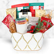 Load image into Gallery viewer, A holiday gift basket filled with assorted gourmet treats, including Capuccino coffee, biscotti, Mighty Leaf tea, and red berries, presented in a white ceramic bucket with gold leaf patterns on a white marble background.
