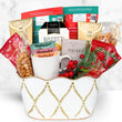Load image into Gallery viewer, A holiday gift basket filled with assorted gourmet treats, including Capuccino coffee, biscotti, Mighty Leaf tea, and red berries, presented in a white ceramic bucket with gold leaf patterns on a white marble background.
