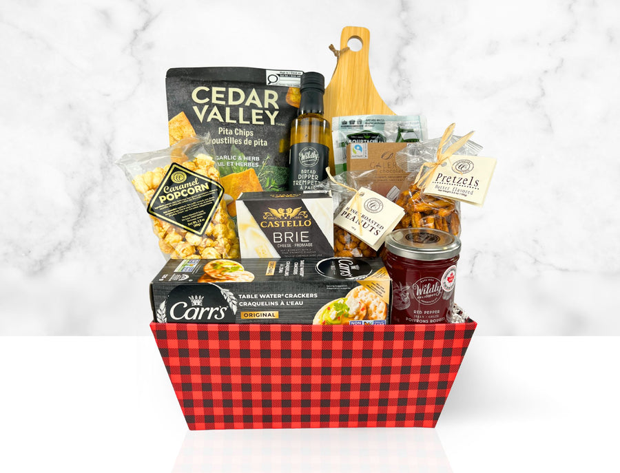 Gourmet gift basket with snacks and drinks on a white background